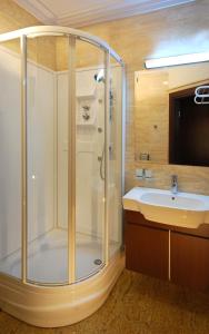 a bathroom with a shower, sink, and toilet at Hotel Victoria in Włocławek