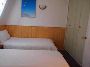レ・デュー・アルプにあるAlpine Hideoutのベッド2台と窓が備わる小さな客室です。