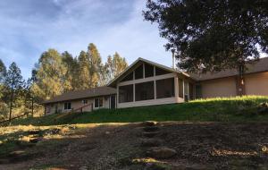a house sitting on top of a lush green hill at Foxtail Farm Bed & Breakfast in Ponderosa Basin