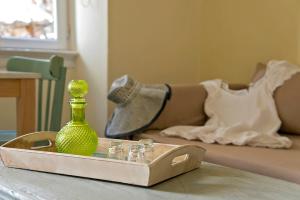 a green vase sitting on a table next to a bed at Antica Casa Studios in Chania