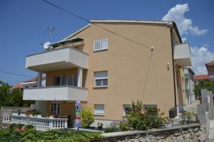 a large yellow house with a balcony at Apartman Latin 1 in Vodice