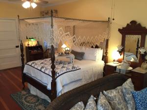 a bedroom with a bed with a net canopy at Magnolia Cottage Bed and Breakfast in Natchez