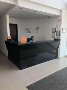 una persona sentada en un mostrador en un vestíbulo en Hotel Via 40, en Barranquilla