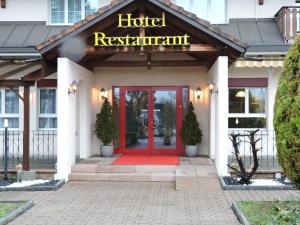 a hotel with a red door and a hotel restaurant at Hotel Schoenau in Wohlen