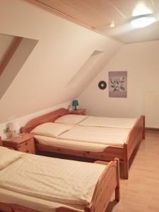 a bedroom with three beds in a attic at Hotel Restaurant Parthenon in Otterbach