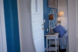 a bedroom with a white bed and a blue wall at Cento Passi dal Duomo B&B in Arezzo