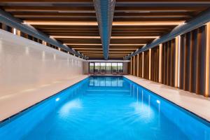 a large swimming pool with blue water in a building at Hyatt House Gebze in Gebze