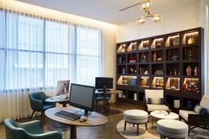 a room with a desk with a computer and chairs at Hyatt Place Bangkok Sukhumvit 24 in Bangkok
