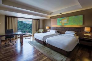 a hotel room with a bed and a television at Hyatt Regency Kinabalu in Kota Kinabalu