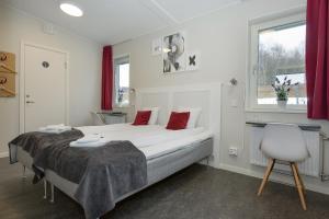 a bedroom with a bed and a chair and a window at Hotell Eken Mölndal in Mölndal