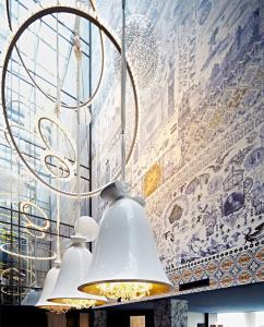 a group of lights hanging from a wall with a mural at Andaz Amsterdam Prinsengracht - a concept by Hyatt in Amsterdam