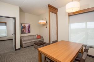 a living room with a table and a couch at Hyatt Place Cincinnati/Sharonville Convention Center in Sharonville