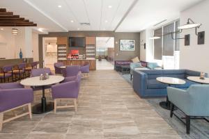 a waiting room with tables and purple chairs at Hyatt Place Cincinnati/Sharonville Convention Center in Sharonville