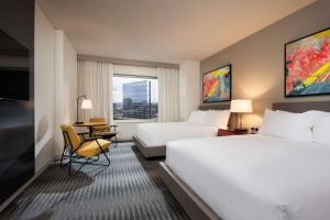 a hotel room with two beds and a table and chairs at Hyatt Regency Bloomington - Minneapolis in Bloomington