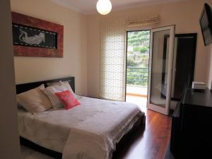 sypialnia z łóżkiem i przesuwanymi szklanymi drzwiami w obiekcie Apartment Villa Sol II w mieście Ponta do Sol