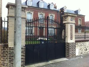 a black gate in front of a brick house at Chambre meublée in Saint-Aubin-lès-Elbeuf