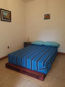 a bedroom with a bed with a blue striped blanket at Paraíso San José in Santa Cruz Verapaz
