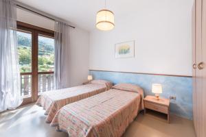 a hotel room with two beds and a window at Albergo Cinzia in Vattaro