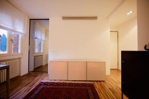 un soggiorno con parete bianca e tappeto di piccola corte a Venezia
