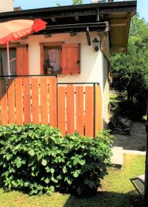 a house with a fence and a bush in front of it at Casa Bucaneve & Ciclamino in Gravedona