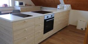 a kitchen with wooden cabinets and a stove top oven at Skútustadir Guesthouse in Myvatn