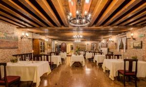 a dining room with white tables and chairs and a chandelier at Best Western Plus Hotel Villa Tacchi in Gazzo
