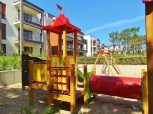 Un parque infantil frente a un edificio con un tobogán. en Apartment Panorama, en Międzywodzie