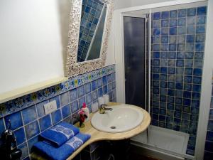 フォルツァ・ダグロにある'Casa La Zagara'の青いタイル張りのバスルーム(シンク、鏡付)