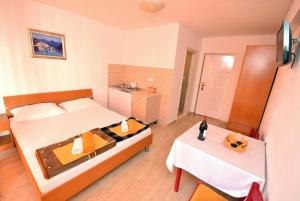 a bedroom with a bed and a table with a bottle of wine at Apartmani Spaic in Herceg-Novi