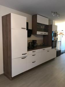 a kitchen with white cabinets and a white refrigerator at Fewo Zweisamkeit renoviert inkl Fahrräder in Graal-Müritz