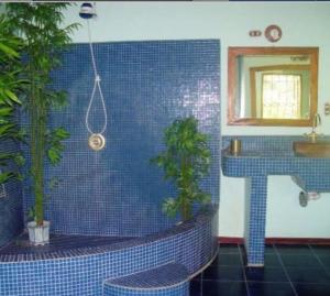 a blue tiled bathroom with a sink and two plants at Casa Paraíso in Pavones