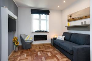 - un salon avec un canapé et une cheminée dans l'établissement Sunflower Apartment, à Cracovie