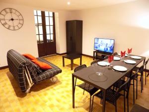 uma sala de estar com uma mesa e cadeiras e uma televisão em Maison Roosevelt - Charleroi Airport - Ideal Families em Charleroi