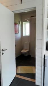 a bathroom with a toilet and a window and a door at The Studio in Klövedal