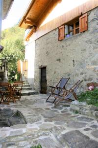 a patio with two picnic tables and a building at Casa Bucaneve & Ciclamino in Gravedona