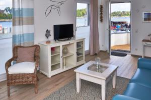 a living room with a tv and a chair at Apartment Lütte Bris in Eckernförde