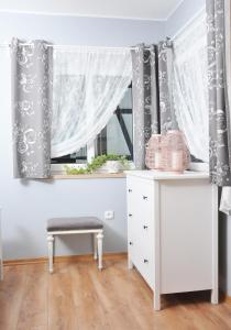 ZałakowoにあるStanlejówkaのテーブルとカーテン付きの窓が備わる客室です。