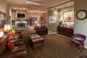 Stratford Suites Spokane Airport في إيرواي هايتس: غرفة معيشة مع أريكة ومدفأة