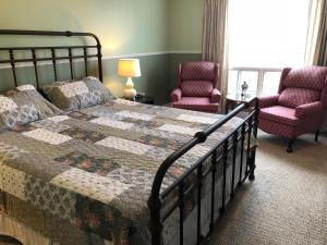 a bedroom with a bed and two chairs at Bayside Inn in Digby