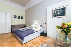 um quarto com uma cama e um vaso de flores em Apartment Nebovidy I - Free Parking - Terrace - Air Conditioning em Praga