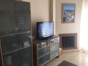 una sala de estar con TV en un vestidor con chimenea en Calahonda Royale, en Cabopino