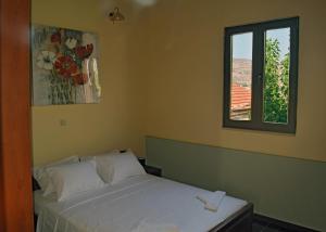 a bedroom with a white bed and a window at Venetian Cistern Villa in Kalamítsion Alexándrou