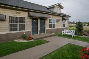 ein Haus mit einer Bank davor in der Unterkunft Stratford Suites Spokane Airport in Airway Heights