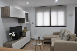 a living room with a couch and a tv at La Casita De Angela in Frigiliana