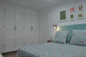 フリヒリアナにあるLa Casita De Angelaのベッドルーム(ベッド1台、白いキャビネット付)