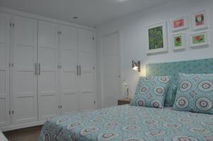 a bedroom with a bed and white cabinets at La Casita De Angela in Frigiliana