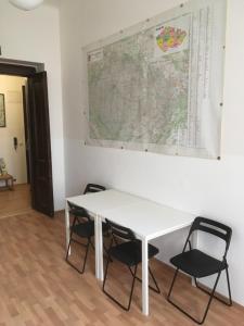 
a table and chairs in front of a wall at Hostel EMMA in Prague
