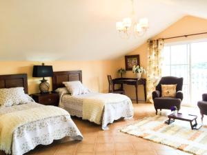 a bedroom with two beds and a chair and a chandelier at Villa con Arte Jacuzzi By Mila Prieto in Algar