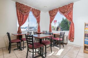 a dining room with tables and chairs and a window at Super 8 by Wyndham Bernalillo in Bernalillo