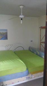 um quarto com 2 camas e lençóis verdes em Solar Dona Irma em Guaratuba